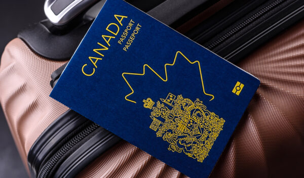 International passport of a citizen of Canada on a suitcase, departure from the airport, international travel