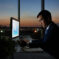 Serious Vietnamese businessman working on financial report in dark office